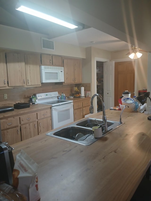 kitchen featuring visible vents, light brown cabinets, a sink, tasteful backsplash, and white appliances