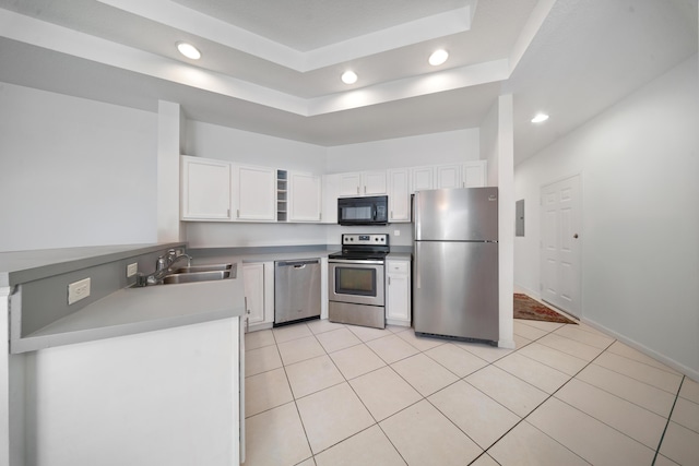 kitchen with a sink, appliances with stainless steel finishes, white cabinets, and light tile patterned floors