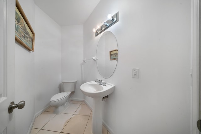 bathroom featuring tile patterned floors, baseboards, and toilet