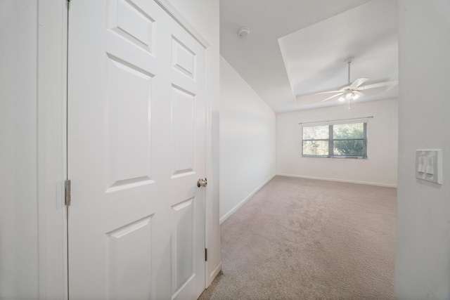 empty room with ceiling fan, baseboards, a tray ceiling, and carpet