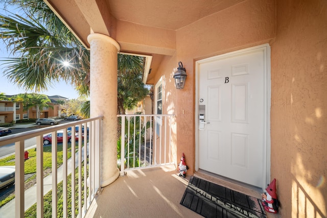 property entrance with stucco siding and a balcony