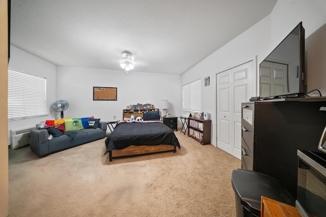 carpeted bedroom with multiple windows and a textured ceiling