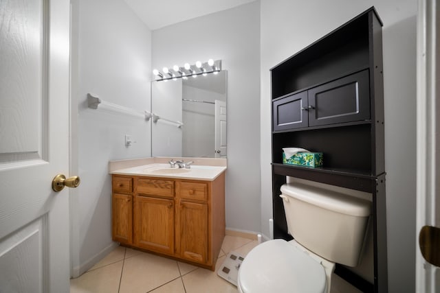 bathroom featuring tile patterned flooring, toilet, vanity, and baseboards