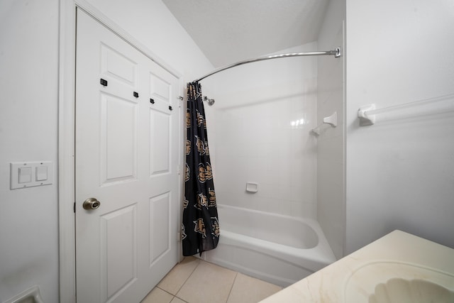 full bath with tile patterned flooring, shower / tub combo with curtain, and a sink