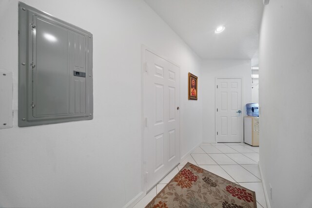 hallway with electric panel, baseboards, light tile patterned flooring, and recessed lighting