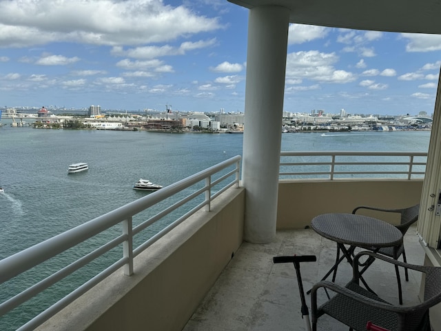 balcony with a water view and a view of city