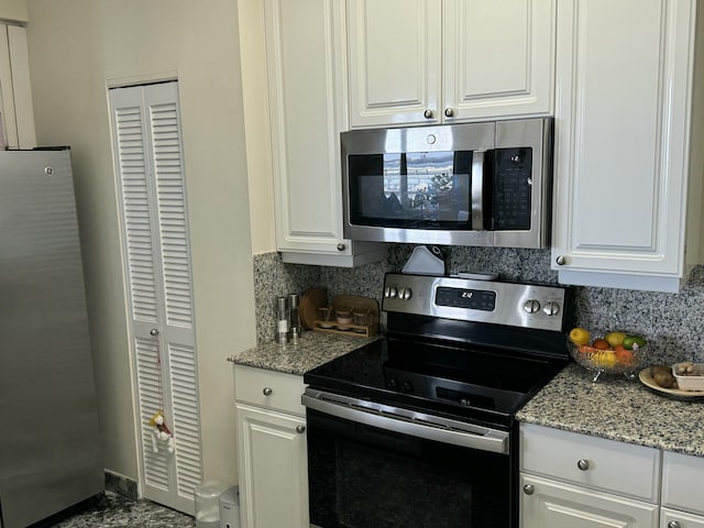 kitchen with white cabinetry, stainless steel appliances, and backsplash