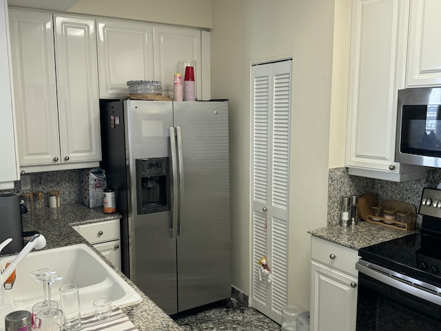 kitchen with light stone counters, tasteful backsplash, appliances with stainless steel finishes, white cabinetry, and a sink