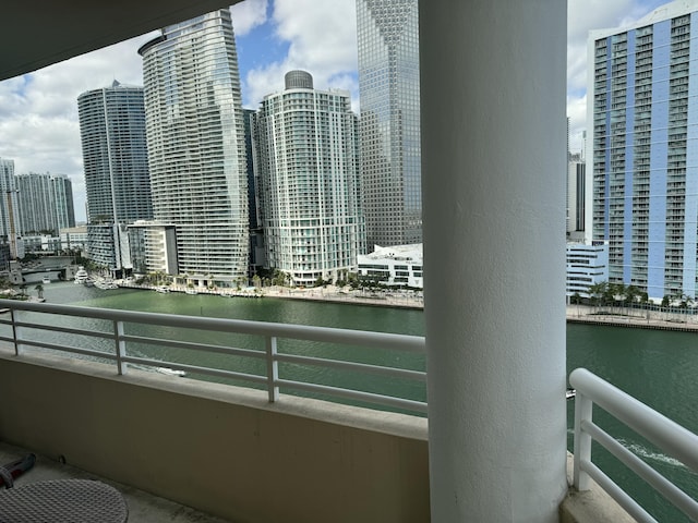 balcony with a water view and a view of city