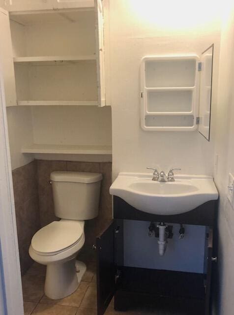 1831 Juno Rd Unit 123, North Palm Beach, FL 33408 - bathroom featuring vanity, toilet, and tile patterned flooring
