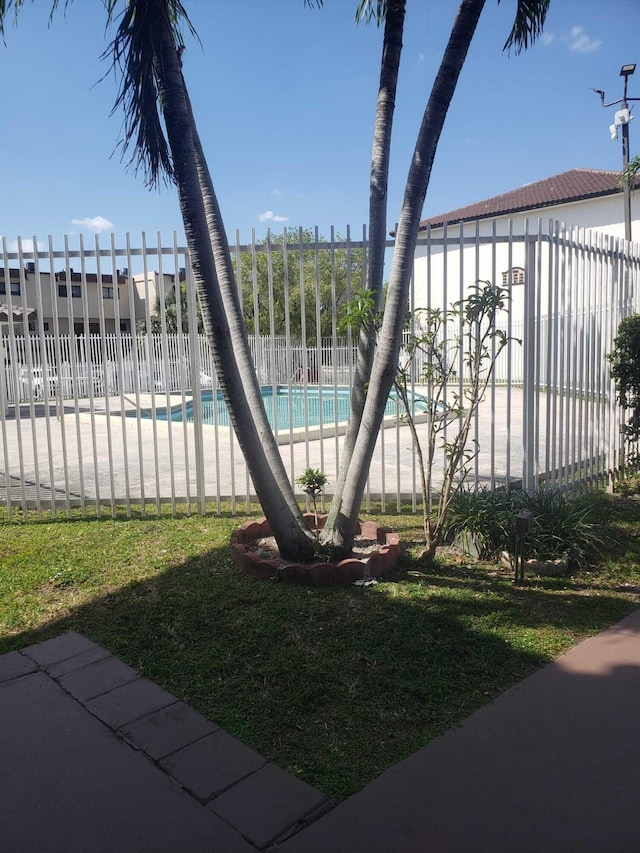 view of yard featuring a community pool and fence