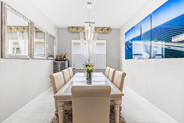 dining room featuring beverage cooler, marble finish floor, an inviting chandelier, and baseboards