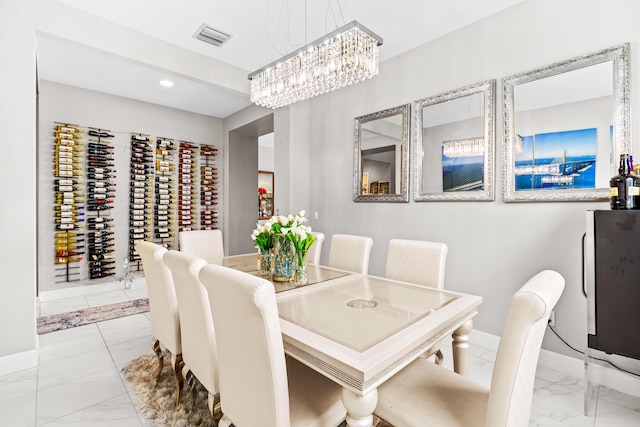 dining room featuring a notable chandelier, baseboards, visible vents, and marble finish floor