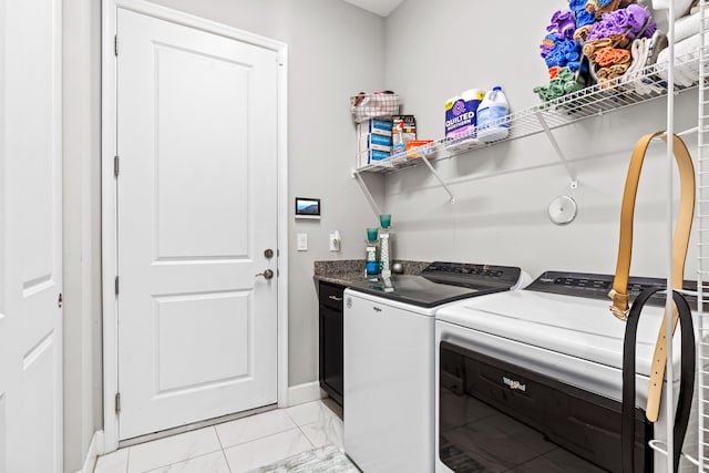 laundry room featuring baseboards, marble finish floor, and washing machine and clothes dryer