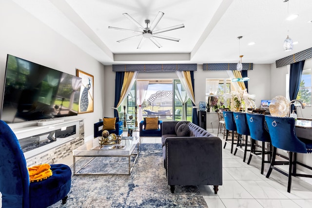 living room featuring a tray ceiling and a ceiling fan