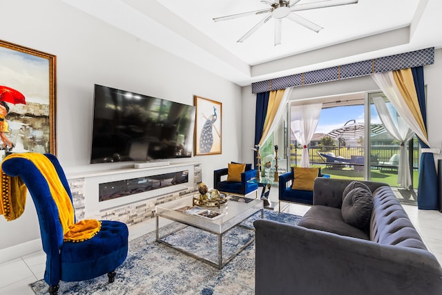 living area featuring tile patterned flooring, a ceiling fan, and baseboards