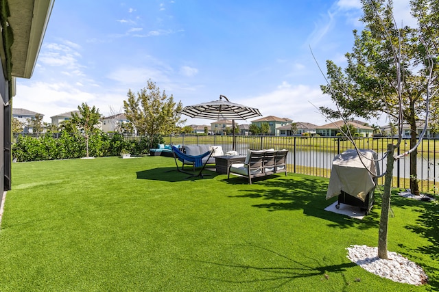 view of yard with an outdoor hangout area, a water view, and fence