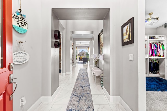 corridor with marble finish floor and baseboards