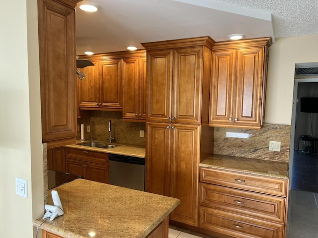 kitchen with brown cabinets, recessed lighting, a sink, stainless steel dishwasher, and tasteful backsplash