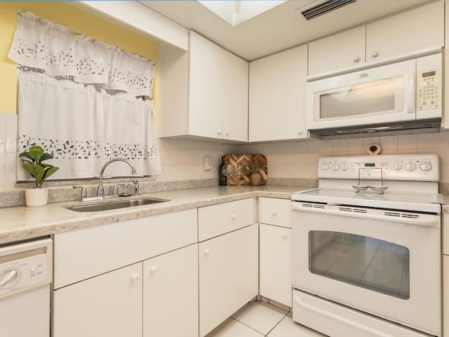 kitchen featuring decorative backsplash, white appliances, and a sink