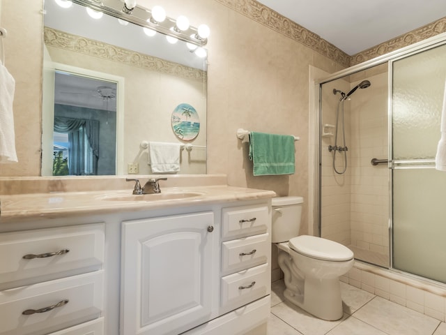 full bath with vanity, tile patterned floors, toilet, and a stall shower