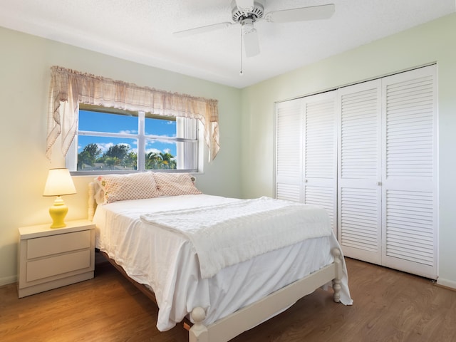 bedroom with a closet, baseboards, light wood-style floors, and a ceiling fan