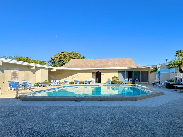 community pool featuring a patio and fence