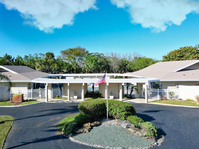 view of building exterior with driveway and fence