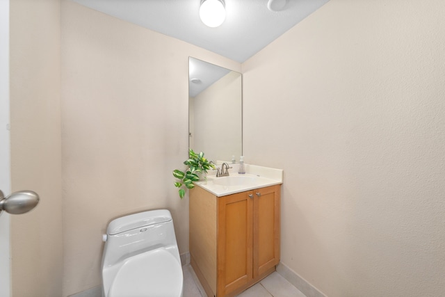 bathroom featuring baseboards, toilet, vanity, and tile patterned flooring