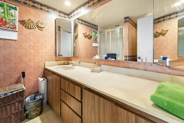 bathroom with a stall shower, vanity, and wallpapered walls