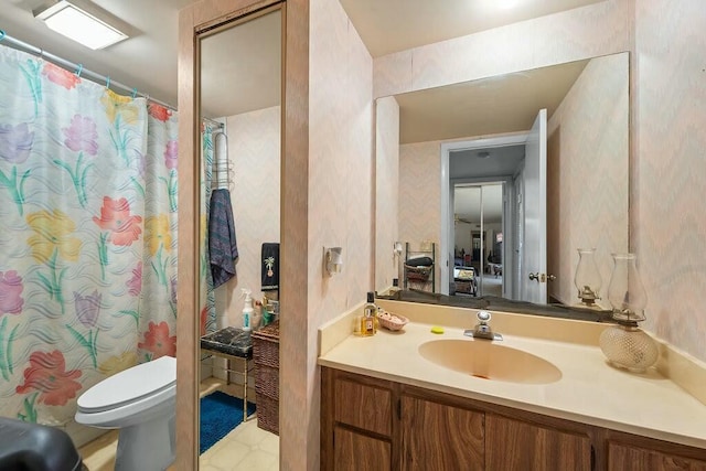 full bathroom with toilet, wallpapered walls, and vanity