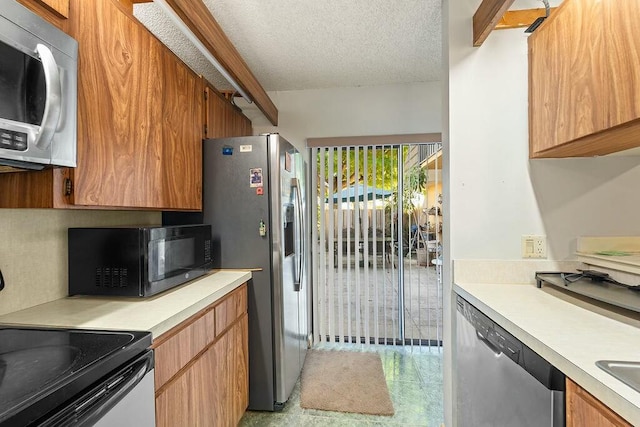 kitchen featuring decorative backsplash, brown cabinets, stainless steel appliances, a textured ceiling, and light countertops