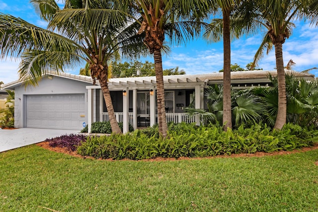 view of front of property with a garage, driveway, a front yard, and stucco siding