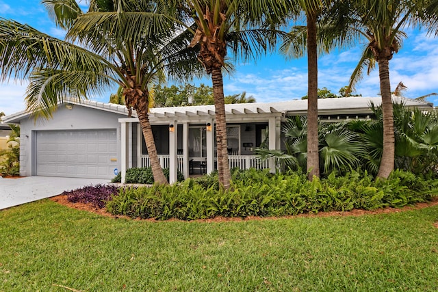 view of front of home with a front lawn, an attached garage, driveway, and stucco siding