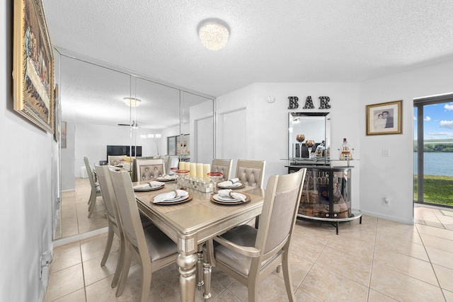 dining area with light tile patterned floors and a textured ceiling