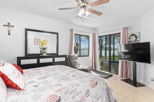 tiled bedroom featuring access to exterior, a textured ceiling, and a ceiling fan