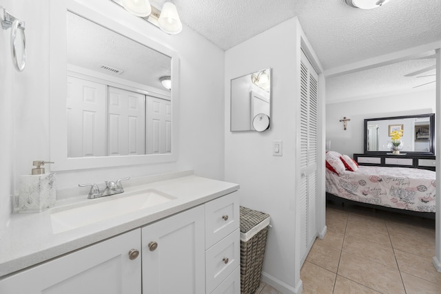 bathroom featuring visible vents, vanity, ensuite bathroom, tile patterned floors, and a textured ceiling