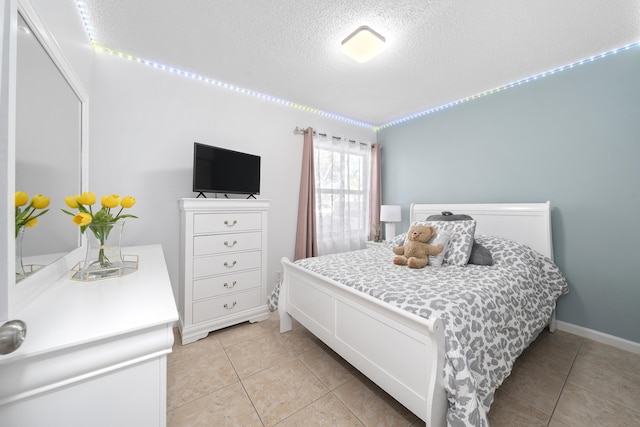 bedroom featuring light tile patterned flooring and a textured ceiling