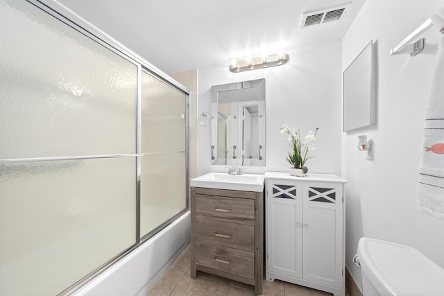 bathroom with vanity, visible vents, enclosed tub / shower combo, tile patterned floors, and toilet