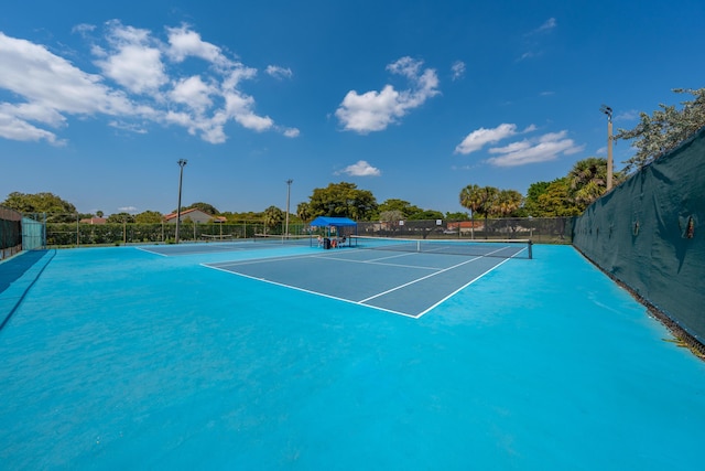 view of tennis court featuring fence