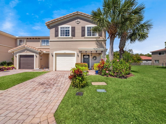 mediterranean / spanish home with stucco siding, a front lawn, a tile roof, decorative driveway, and fence