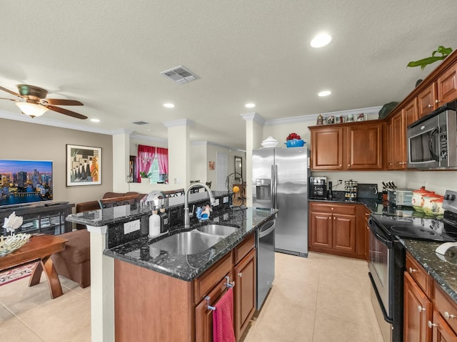 kitchen featuring light tile patterned floors, visible vents, an island with sink, a sink, and stainless steel appliances