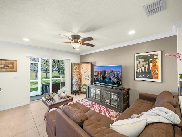 living area featuring light tile patterned floors, a ceiling fan, visible vents, baseboards, and crown molding