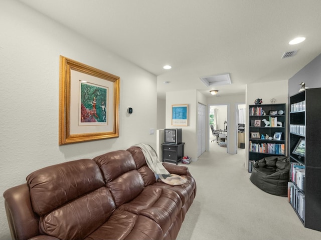 living area featuring attic access, recessed lighting, light colored carpet, and visible vents