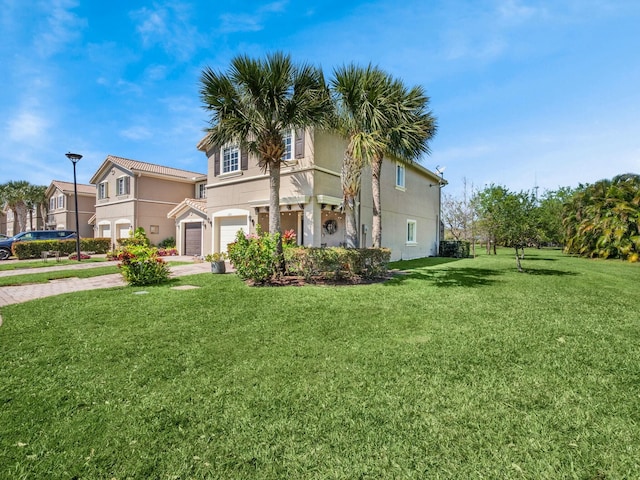 view of front of home featuring a front lawn, an attached garage, driveway, and stucco siding