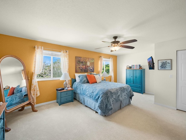 carpeted bedroom with baseboards, a textured ceiling, and a ceiling fan