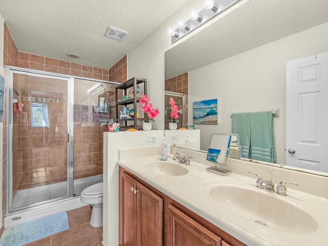 bathroom featuring a shower stall, toilet, visible vents, and a sink