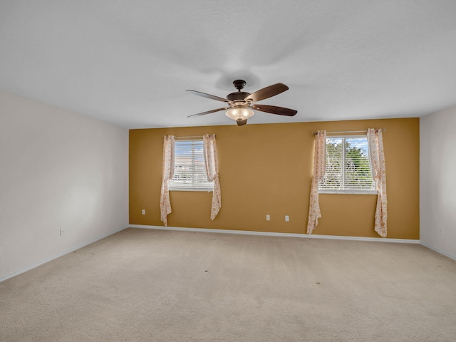 2185 SW Rockport Rd, Port Saint Lucie, FL 34953 - spare room featuring light colored carpet, baseboards, and a ceiling fan