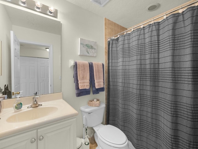 bathroom featuring visible vents, toilet, vanity, a shower with shower curtain, and a textured ceiling