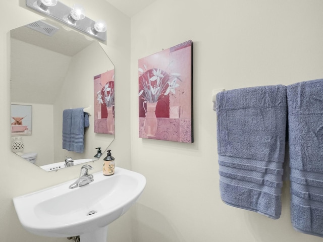 2185 SW Rockport Rd, Port Saint Lucie, FL 34953 - half bath with lofted ceiling, visible vents, and a sink